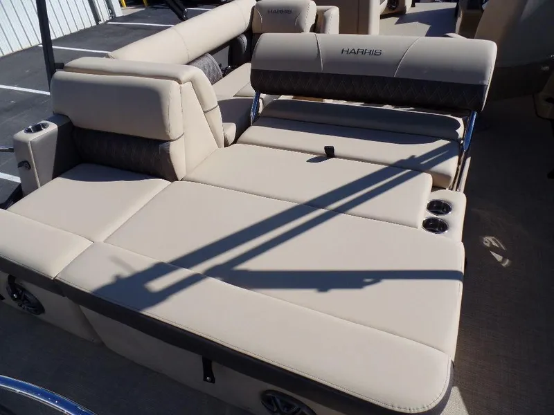 Slide: The Image of 2024 Harris Sunliner 250 boat with beige cushioned seating and cup holders. - 14