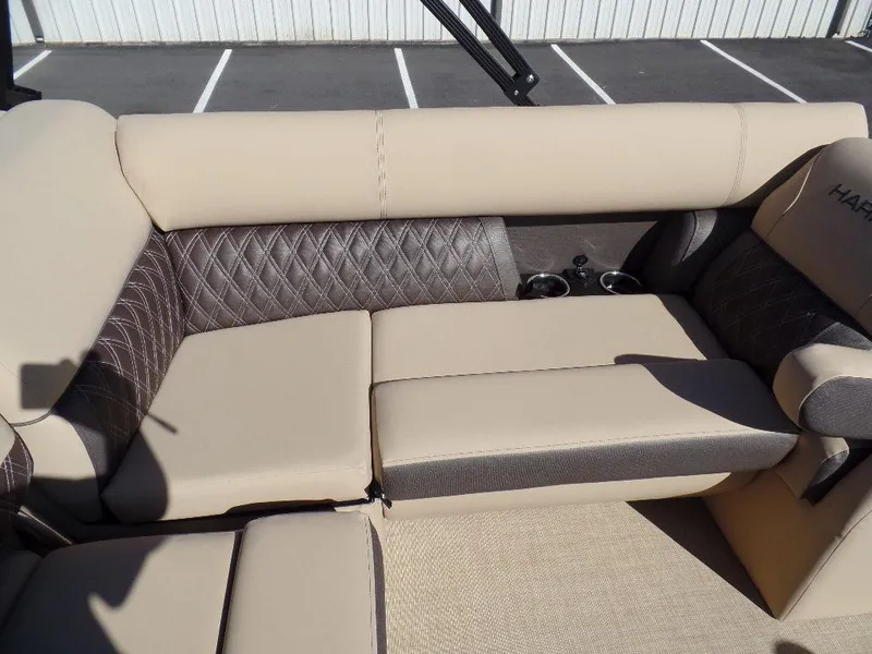 Slide: The Image of 2024 Harris Sunliner 250 boat interior with beige and gray diamond-stitched seating. - 15