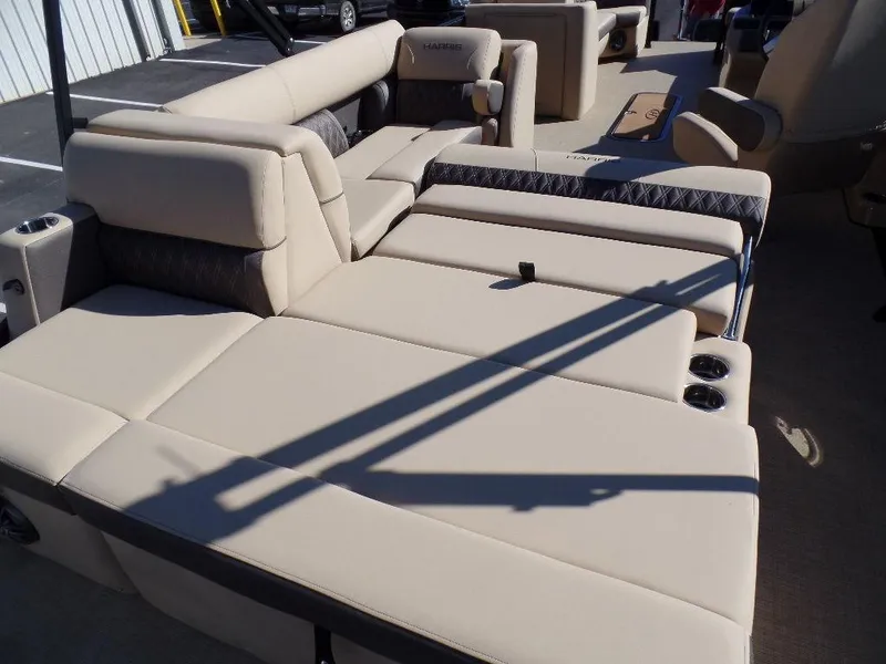 Slide: The Image of 2024 Harris Sunliner 250 boat with beige cushioned seating. - 17