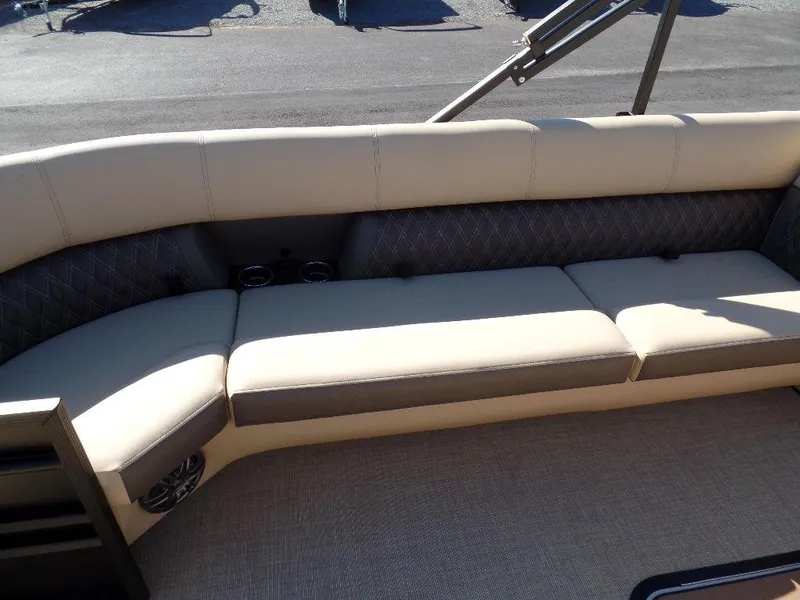 Slide: The Image of 2024 Harris Sunliner 250 boat with beige and gray cushioned seating. - 6