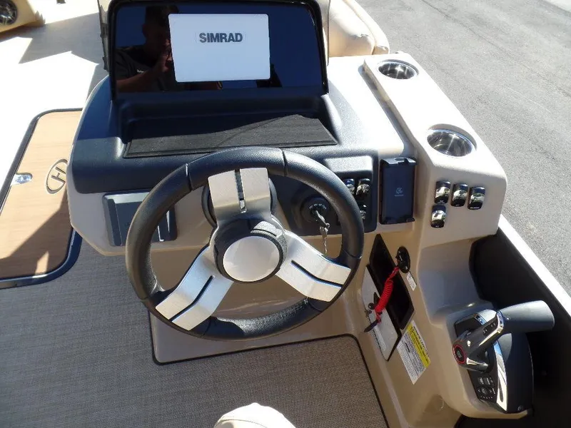 Slide: The Image of 2024 Harris Sunliner 250 boat dashboard with steering wheel and Simrad display. - 8