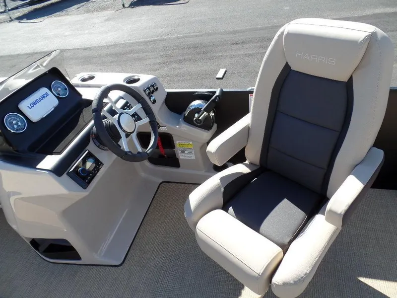 Slide: The Image of 2024 Harris Cruiser 230 boat cockpit with steering wheel and captain's chair. - 10