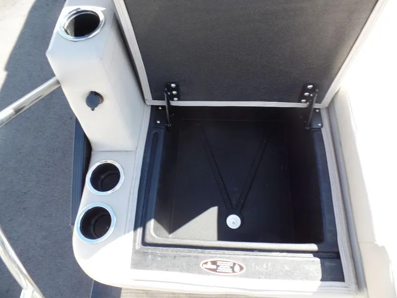 Slide: The Image of Open storage compartment with cup holders on a 2024 Harris Cruiser 230 boat. - 12