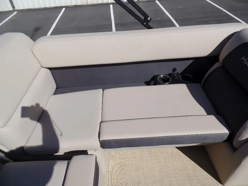 Slide: The Image of 2024 Harris Cruiser 230 boat interior with beige seating and cup holders. - 15