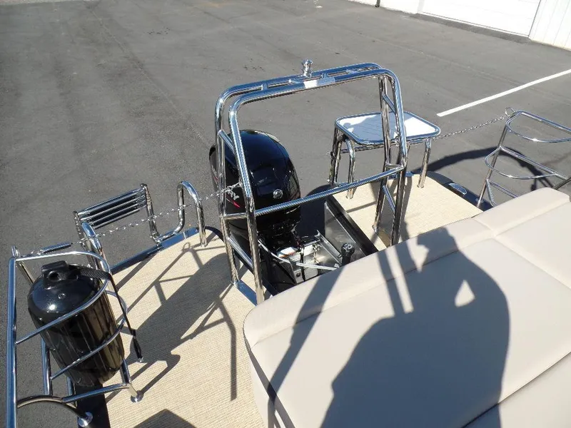 Slide: The Image of 2024 Harris Cruiser 230 boat rear view with motor and seating. - 16