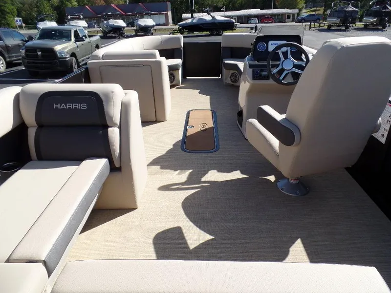 Slide: The Image of 2024 Harris Cruiser 230 boat interior with beige seating and steering console. - 17