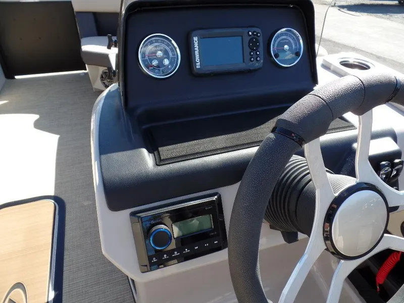 Slide: The Image of 2024 Harris Cruiser 230 boat dashboard with steering wheel and navigation system. - 9