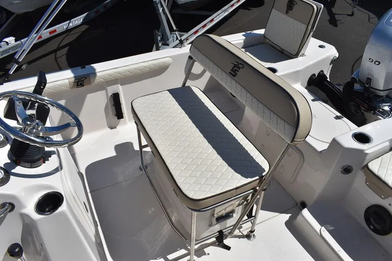 Slide: The Image of 2022 Carolina Skiff 17 LS boat interior with white cushioned seating and steering wheel. - 14