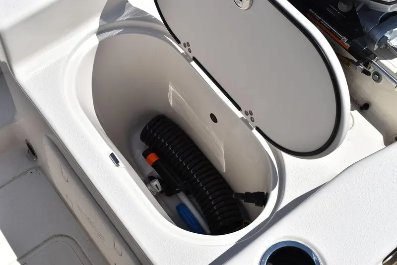 Slide: The Image of 2022 Carolina Skiff 17 LS storage compartment with hose and accessories. - 16