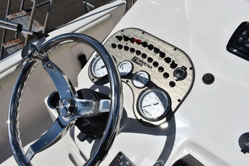 Slide: The Image of 2022 Carolina Skiff 17 LS boat dashboard with steering wheel and control panel. - 21