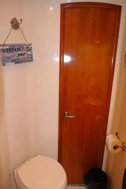Slide: The Image of 2001 Carver 530 Voyager Pilothouse bathroom with wooden door and toilet. - 27