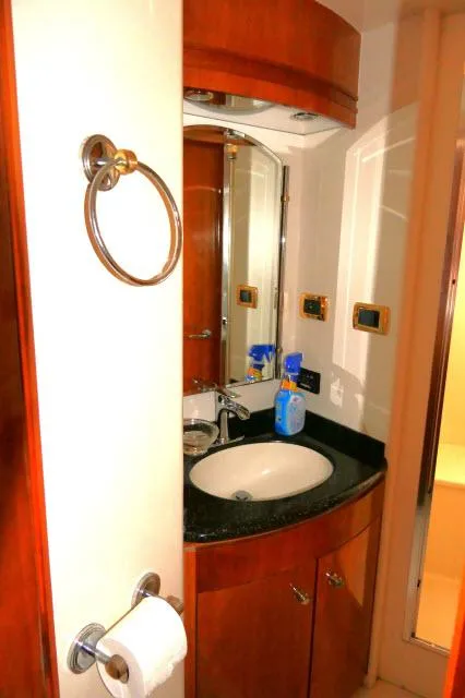 Slide: The Image of 2001 Carver 530 Voyager Pilothouse bathroom with sink, mirror, and wooden cabinetry. - 29