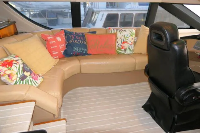 Slide: The Image of 2001 Carver 530 Voyager Pilothouse interior with beige leather seating and colorful pillows. - 33
