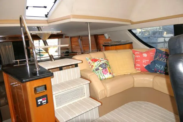 Slide: The Image of Interior of 2001 Carver 530 Voyager Pilothouse with beige leather seating and colorful pillows. - 38