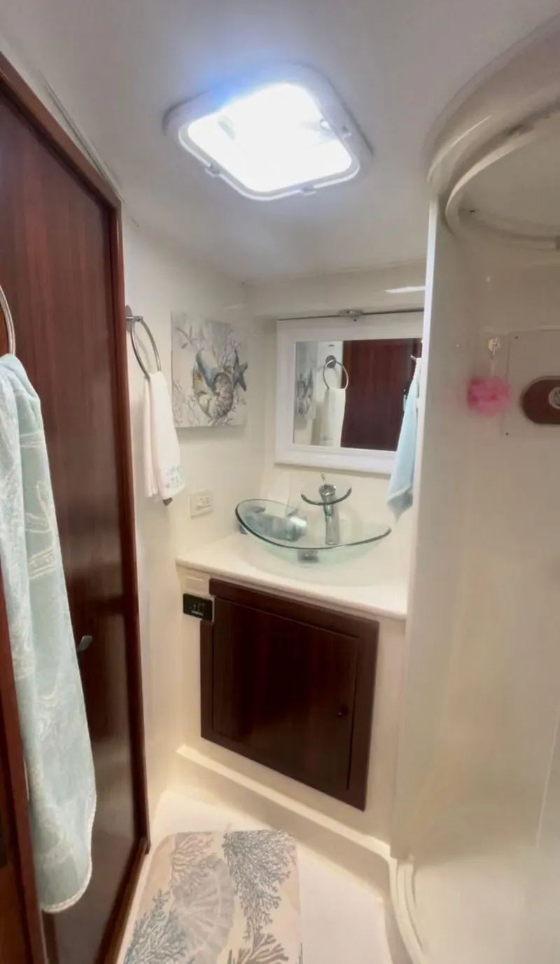 Slide: The Image of 2003 Cabo 45 Express yacht bathroom with modern sink and shower. - 11