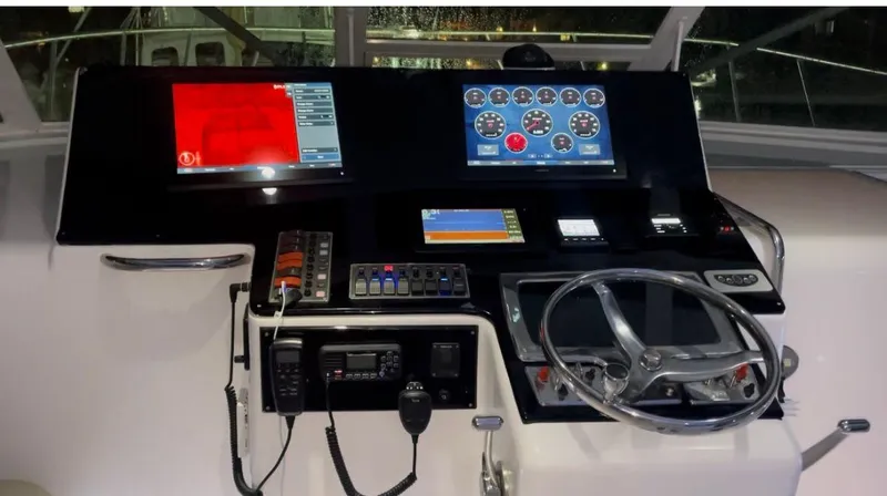 Slide: The Image of Control panel of a 2003 Cabo 45 Express boat with modern navigation equipment. - 14