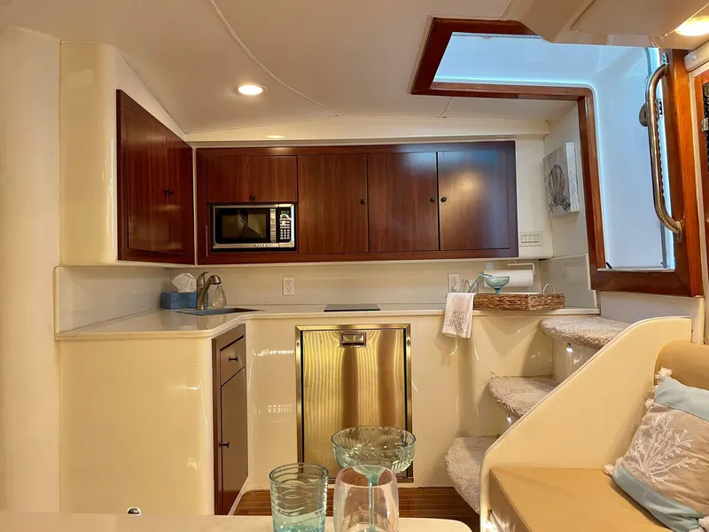Slide: The Image of 2003 Cabo 45 Express yacht interior with modern kitchen and cozy seating area. - 15