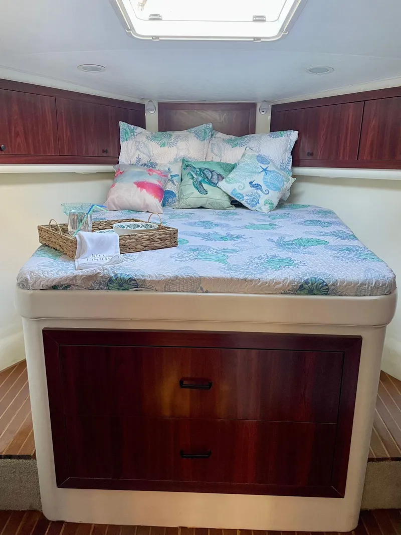 Slide: The Image of Cozy cabin bedroom in a 2003 Cabo 45 Express boat with wooden storage drawers. - 17