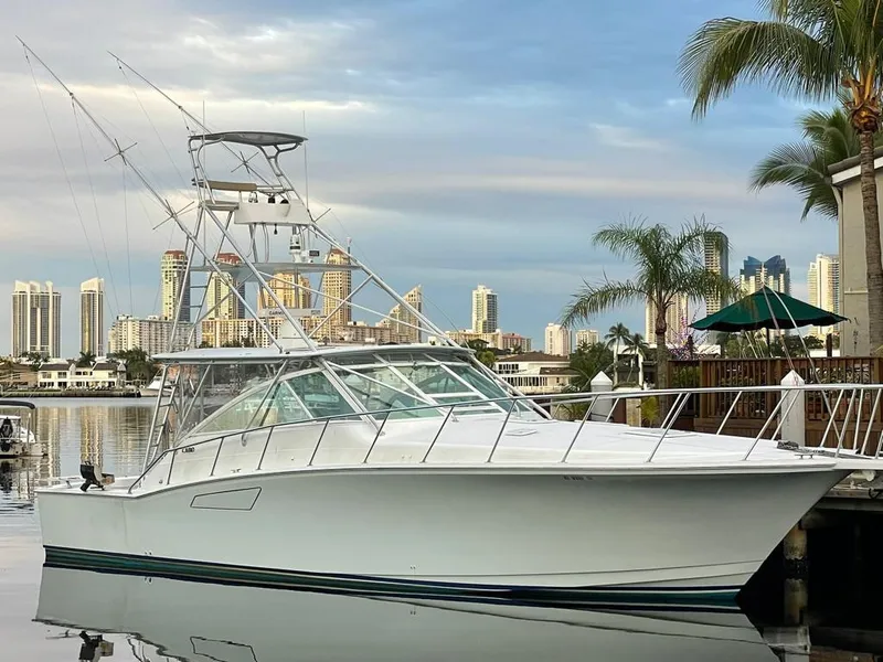 Slide: The Image of 2003 Cabo 45 Express yacht docked with city skyline in the background. - 21