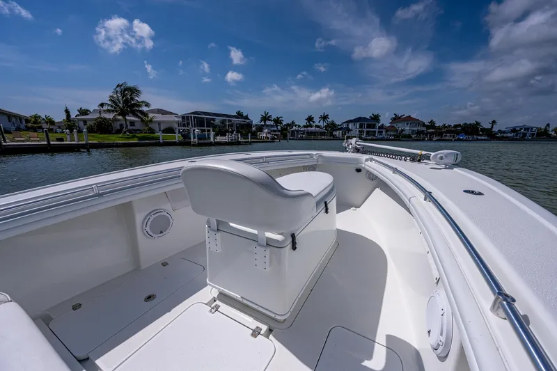 Slide: The Image of 2015 Yellowfin 32 boat interior with white seating and waterfront view. - 12