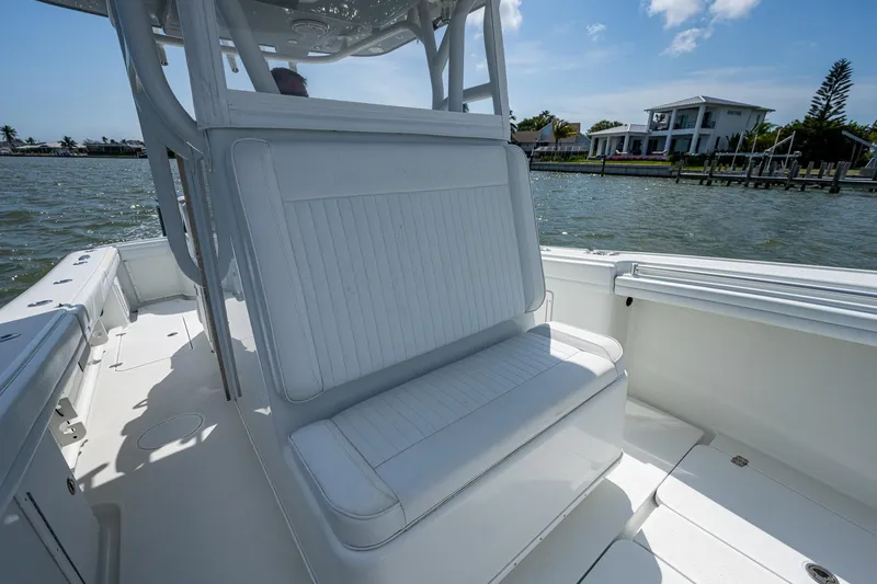 Slide: The Image of 2015 Yellowfin 32 boat interior with white seating, on a sunny day by the water. - 17