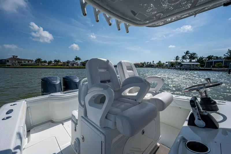 Slide: The Image of 2015 Yellowfin 32 boat interior with dual captain's chairs and scenic waterfront view. - 30