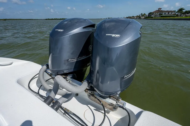 Slide: The Image of Twin outboard engines on a 2015 Yellowfin 32 boat in calm waters. - 34