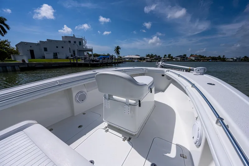 Slide: The Image of 2015 Yellowfin 32 boat interior with white seating and waterfront view. - 9