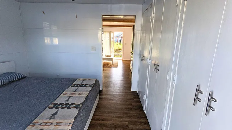 Slide: The Image of Modern 2022 Houseboat bedroom with wood flooring and cozy decor. - 10