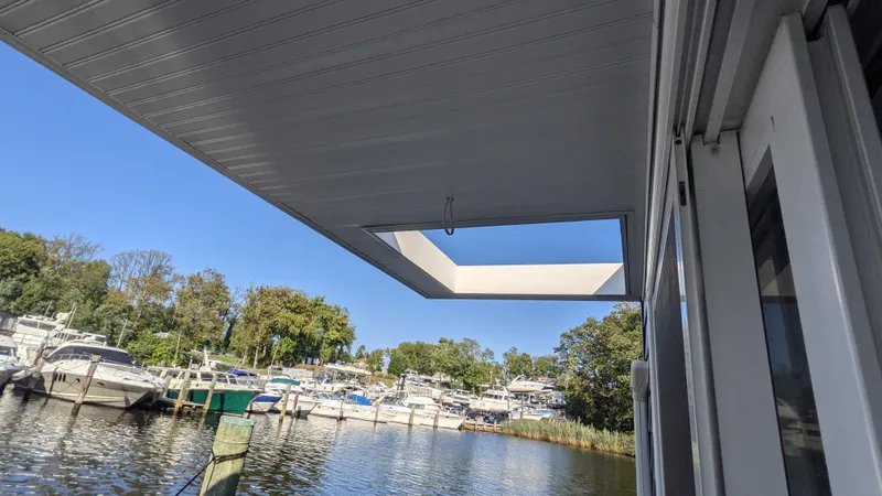 Slide: The Image of Houseboat 36' A&M Manufacturing 2022 docked by a scenic marina with clear blue skies. - 18