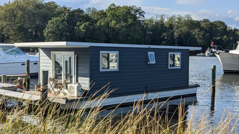 Slide: The Image of Modern 2022 36' A&M Manufacturing houseboat docked on a serene lake. - 2