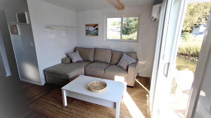 Slide: The Image of Modern 2022 houseboat interior with cozy sofa, coffee table, and natural light. - 4