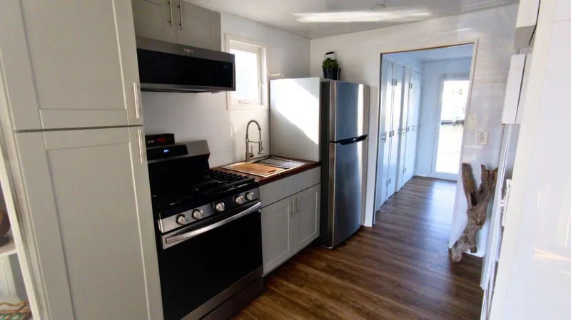 Slide: The Image of Modern kitchen in 2022 36' A&M Manufacturing houseboat with stainless steel appliances. - 6