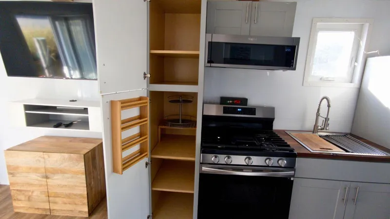Slide: The Image of Modern kitchen in 2022 Houseboat 36' A&M Manufacturing, featuring stove, microwave, and cabinetry. - 7
