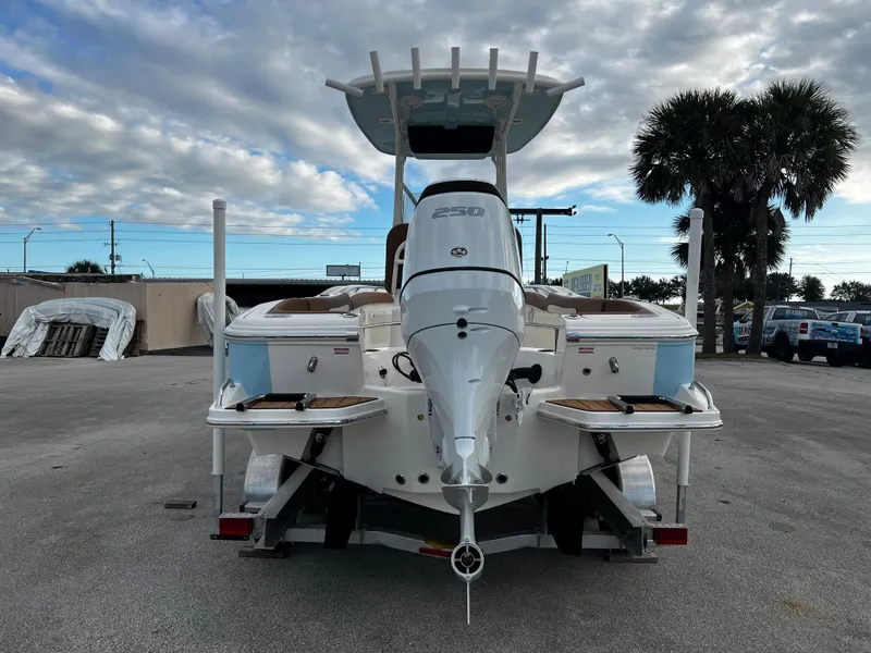 Slide: The Image of 2024 Pioneer 222 Sportfish boat with outboard motor, rear view, parked on trailer. - 14