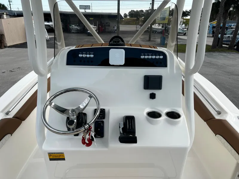 Slide: The Image of 2024 Pioneer 222 Sportfish boat console with steering wheel and controls. - 23