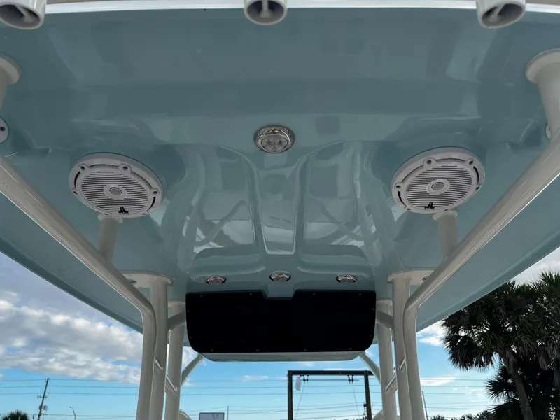 Slide: The Image of 2024 Pioneer 222 Sportfish boat with overhead speakers and blue sky background. - 24