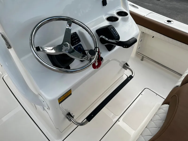 Slide: The Image of 2024 Pioneer 222 Sportfish boat helm with steering wheel and controls. - 25