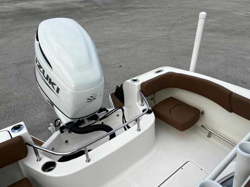 Slide: The Image of 2024 Pioneer 222 Sportfish boat with Suzuki outboard motor and brown seating. - 33