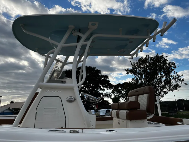 Slide: The Image of 2024 Pioneer 222 Sportfish boat with T-top and seating, under a partly cloudy sky. - 36