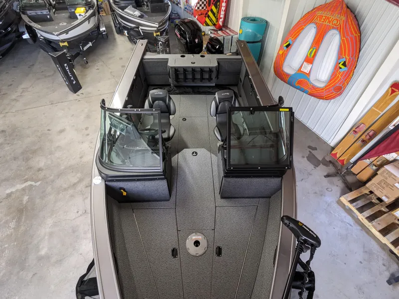 Slide: The Image of 2025 Lund 1875 Fisherman boat interior with seating and windshield in a showroom. - 3