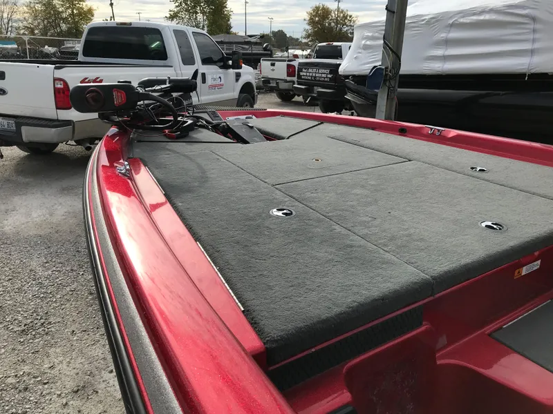 Slide: The Image of 2007 Stratos 285 XL boat with red exterior, parked near trucks and other boats. - 6