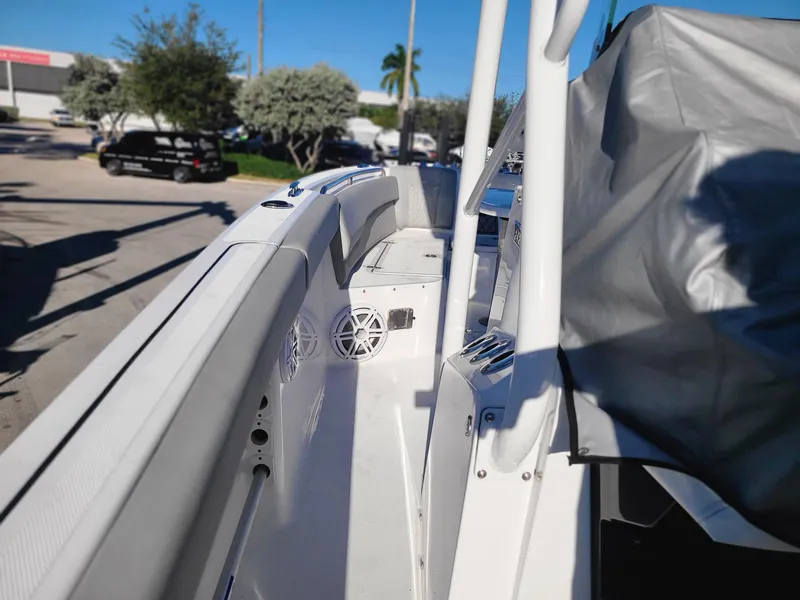 Slide: The Image of 2023 Wellcraft 242 Fisherman boat interior, white deck with speakers and covered seating. - 17