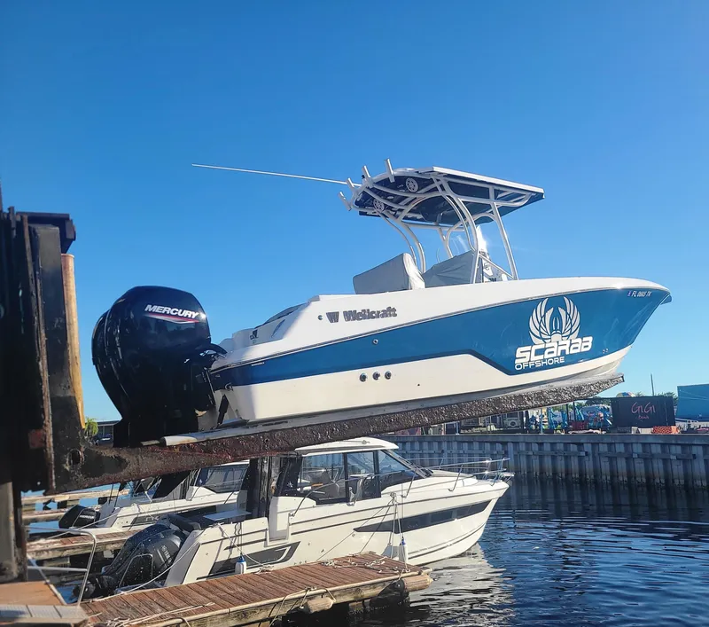 Slide: The Image of 2023 Wellcraft 242 Fisherman boat being lifted at a marina. - 3