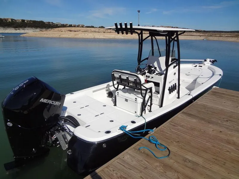 Slide: The Image of 2024 BlackJack 256 Bay boat docked on calm water, featuring a Mercury engine. - 12