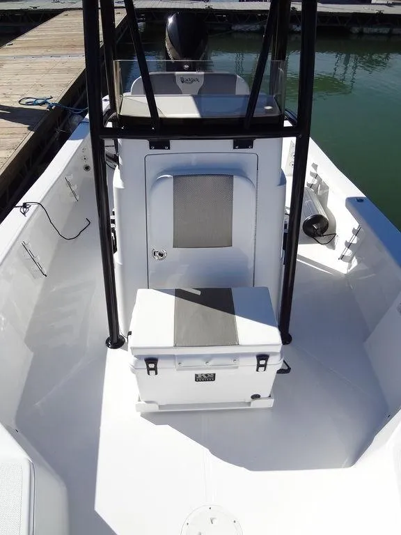Slide: The Image of 2024 BlackJack 256 Bay boat interior with seating and console, docked by the water. - 20
