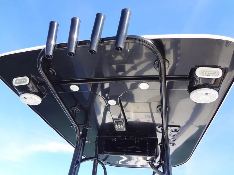 Slide: The Image of 2024 BlackJack 256 Bay boat's T-top with rod holders and lights against blue sky. - 21