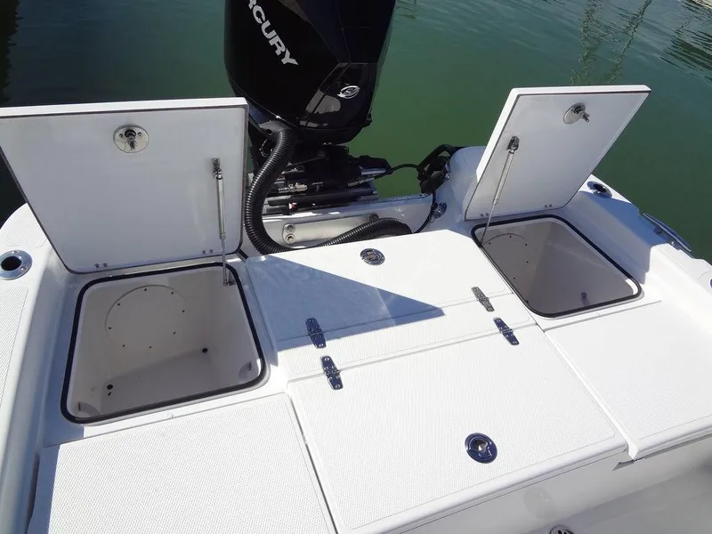 Slide: The Image of 2024 BlackJack 256 Bay boat with open storage compartments and Mercury engine. - 30