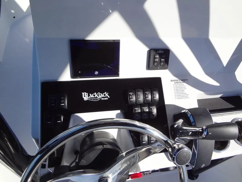 Slide: The Image of 2024 BlackJack 256 Bay boat dashboard with steering wheel and control panel. - 33