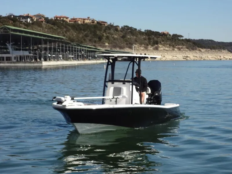 Slide: The Image of 2024 BlackJack 256 Bay boat cruising on a lake near a marina. - 7